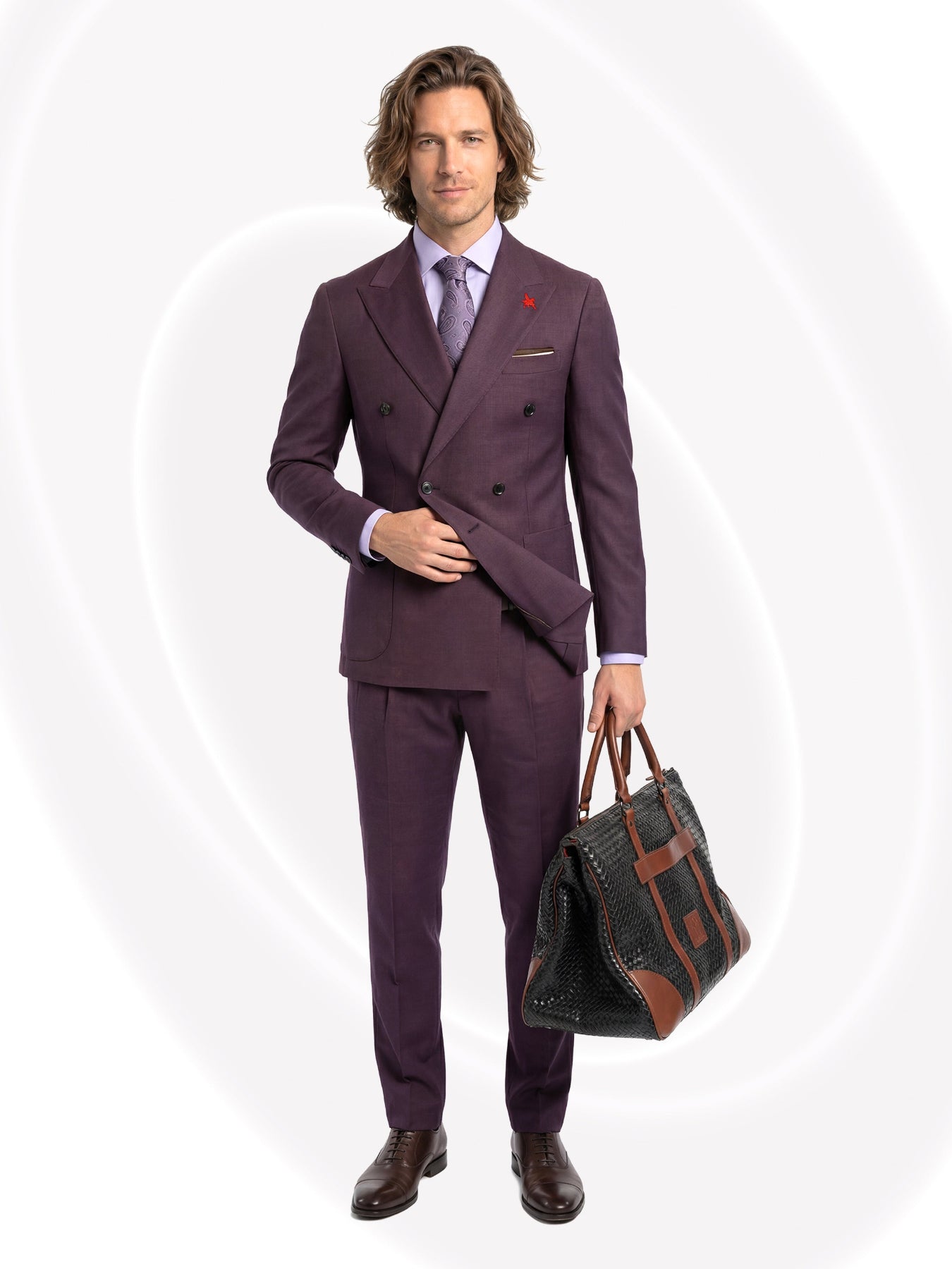 Man wearing a purple suit holding a bag on a white background