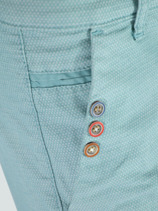 Close-up of a light blue textured fabric with colorful buttons on a white background