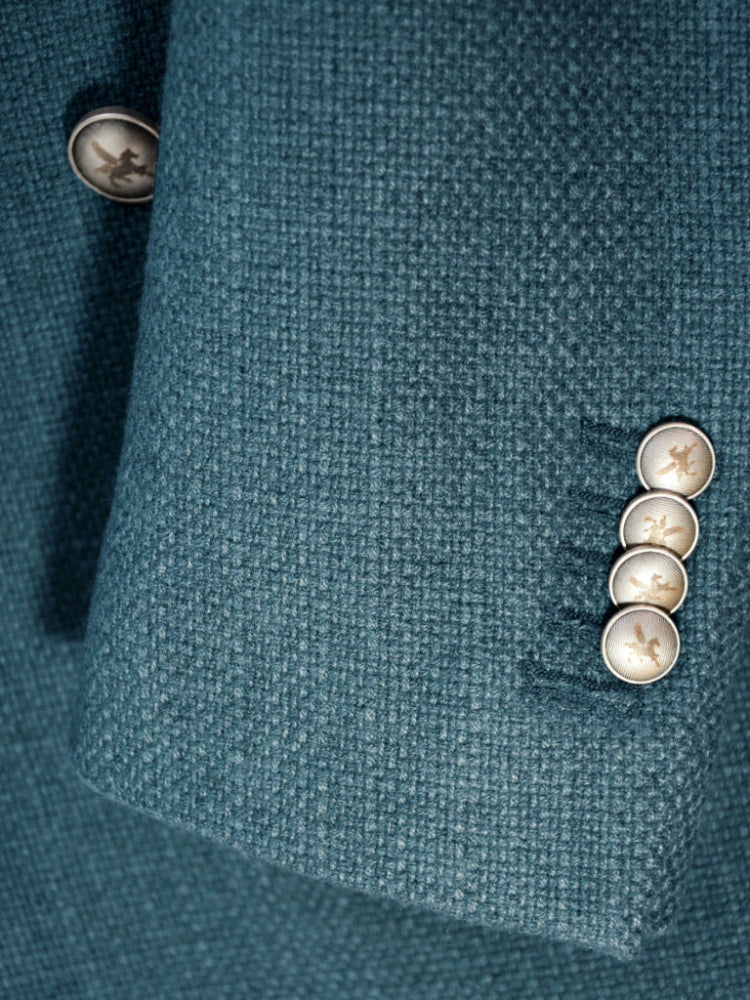 Close-up of a teal fabric with silver buttons