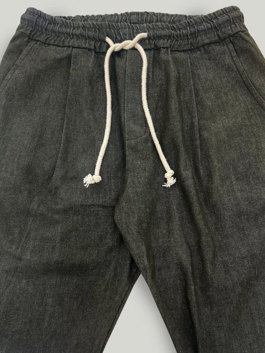 Military green pants with a drawstring on a light gray background