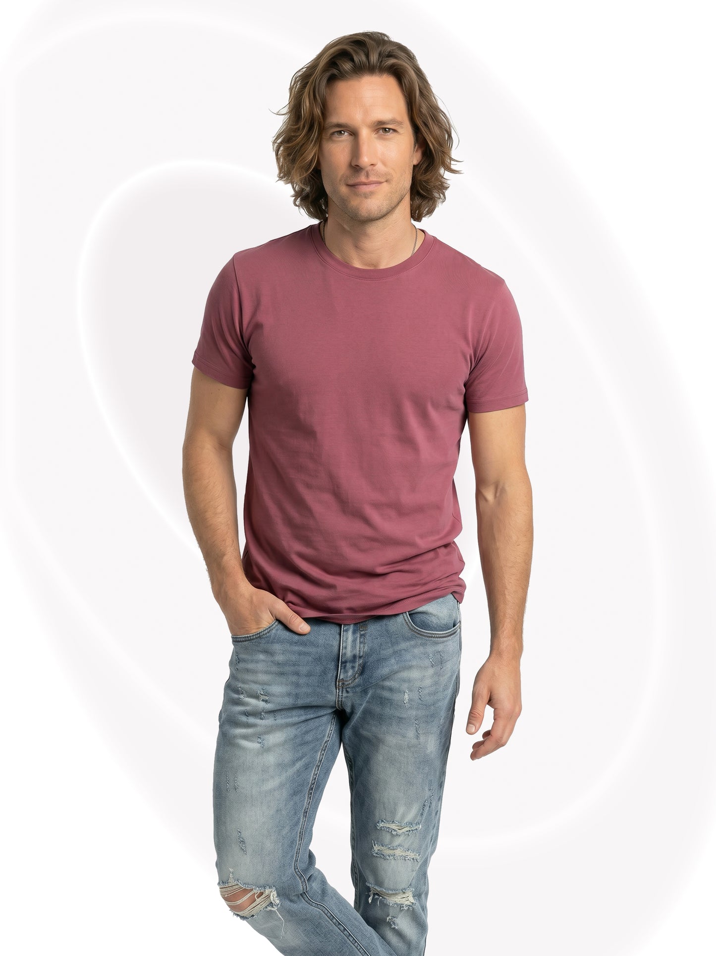 Man wearing a mauve t-shirt and light blue jeans on a white background