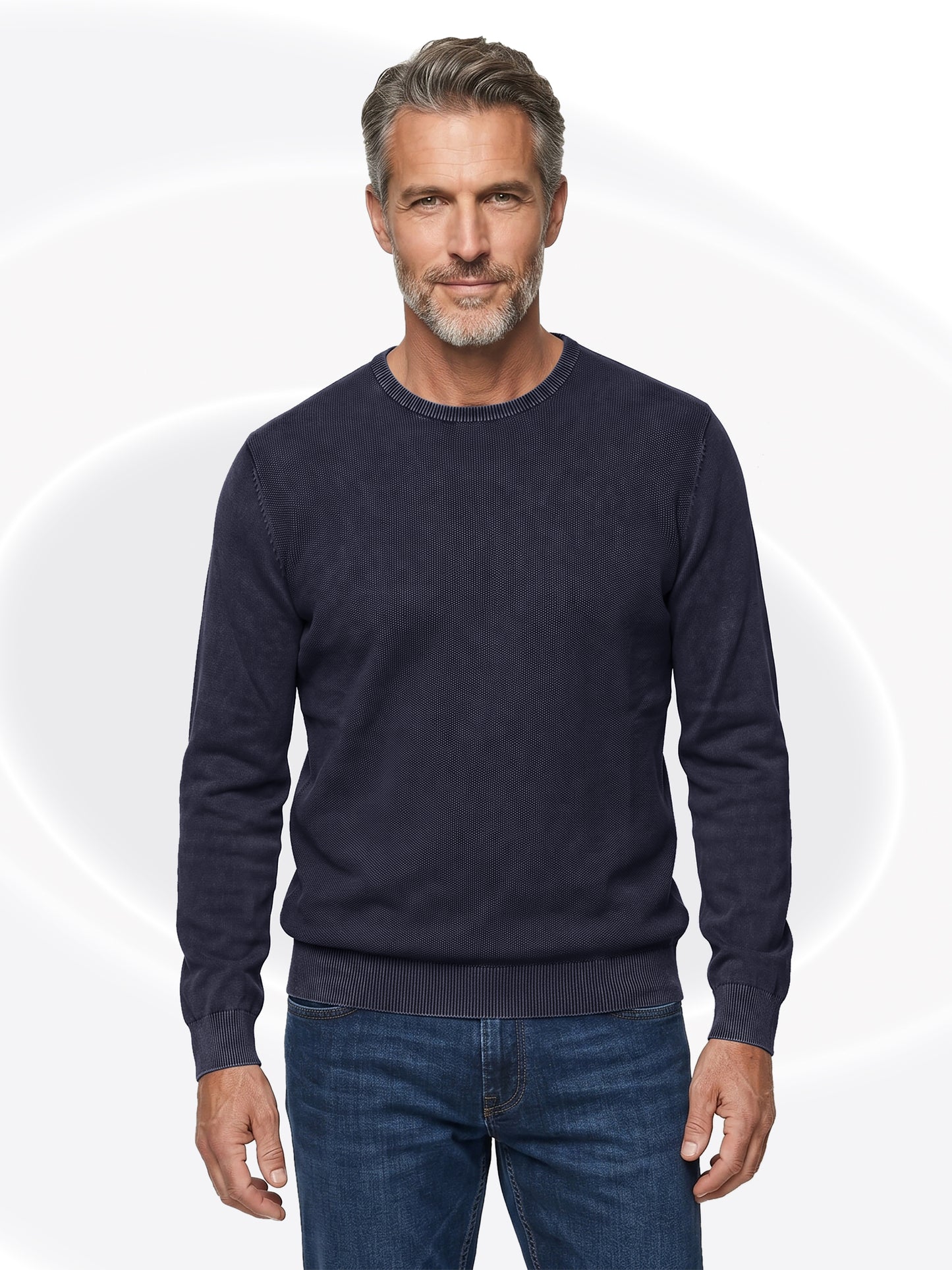 Man wearing a charcoal henley and jeans on a white background