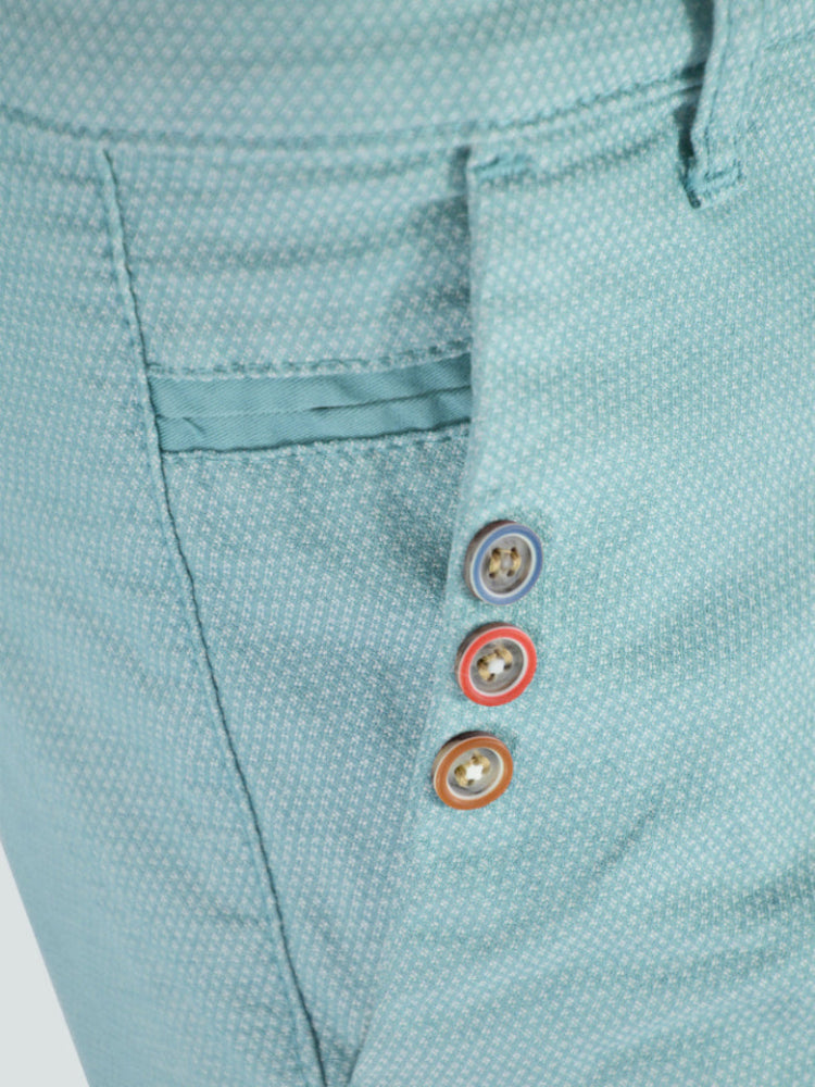 Close-up of a light blue textured fabric with colorful buttons on a white background