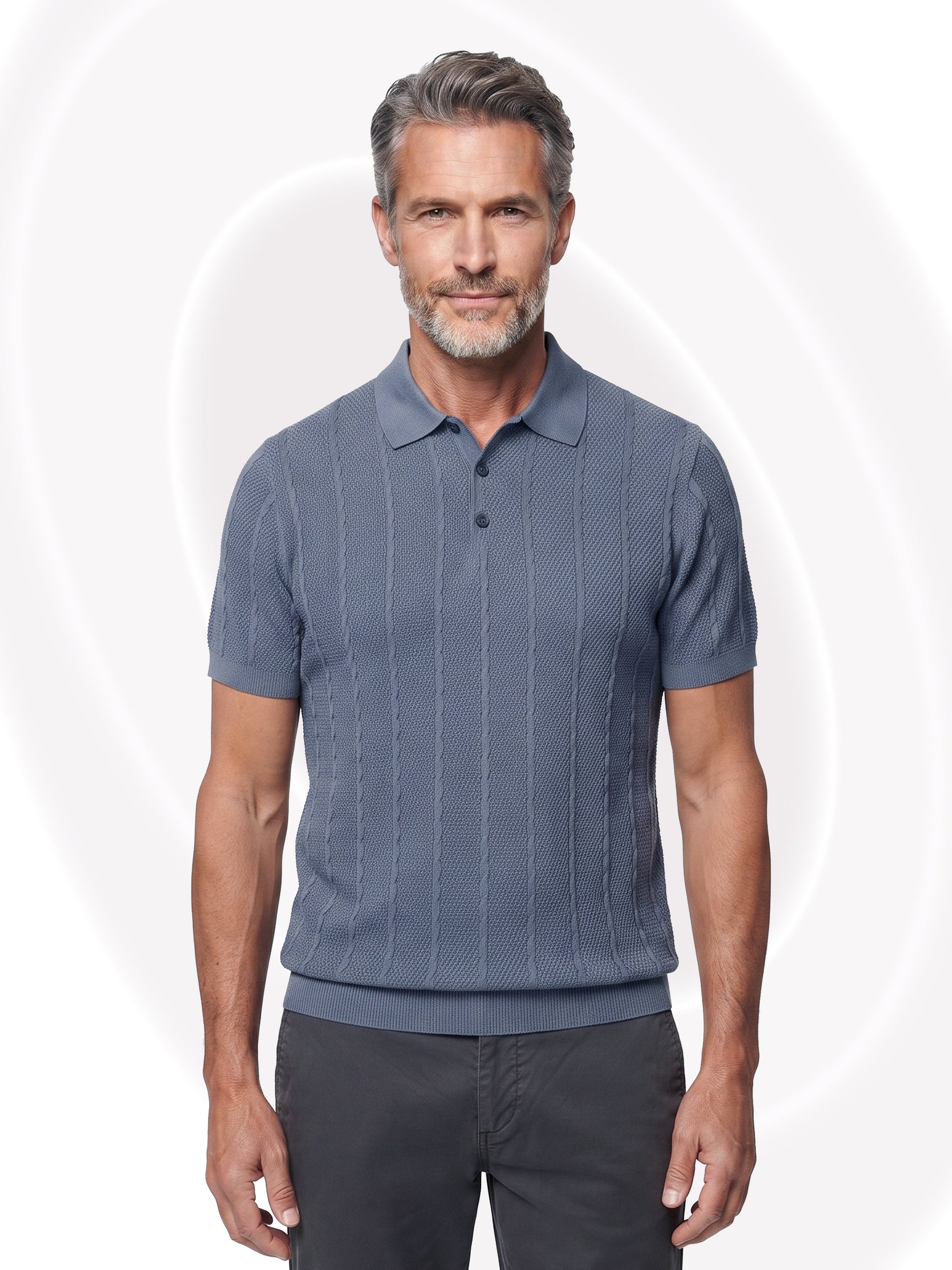 A man wearing a slate blue short-sleeve knit polo shirt with vertical textured stripes, paired with dark gray pants, standing against a white background with faint circular graphic patterns.