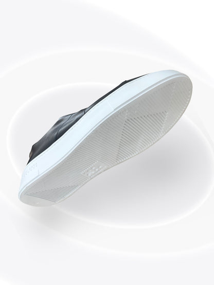 White sneaker with black sole on a white background
