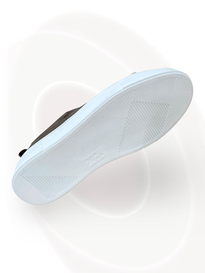 White sneaker with a black sole on a white background