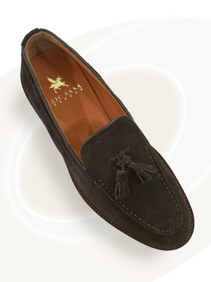 Brown suede loafer with tassel on a white background