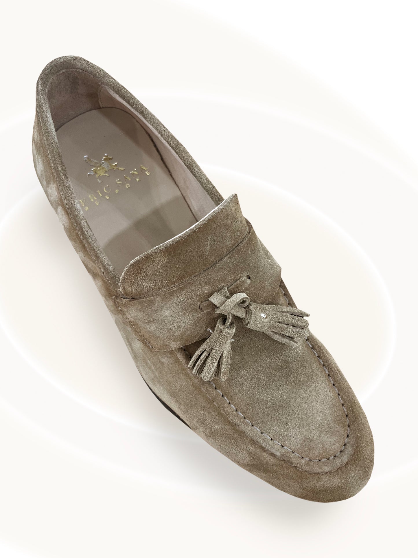 Gray suede loafer with tassel on a white background