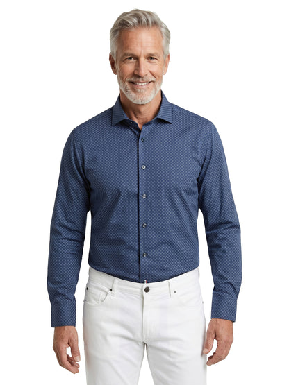 Man wearing a blue patterned shirt and white pants on a white background