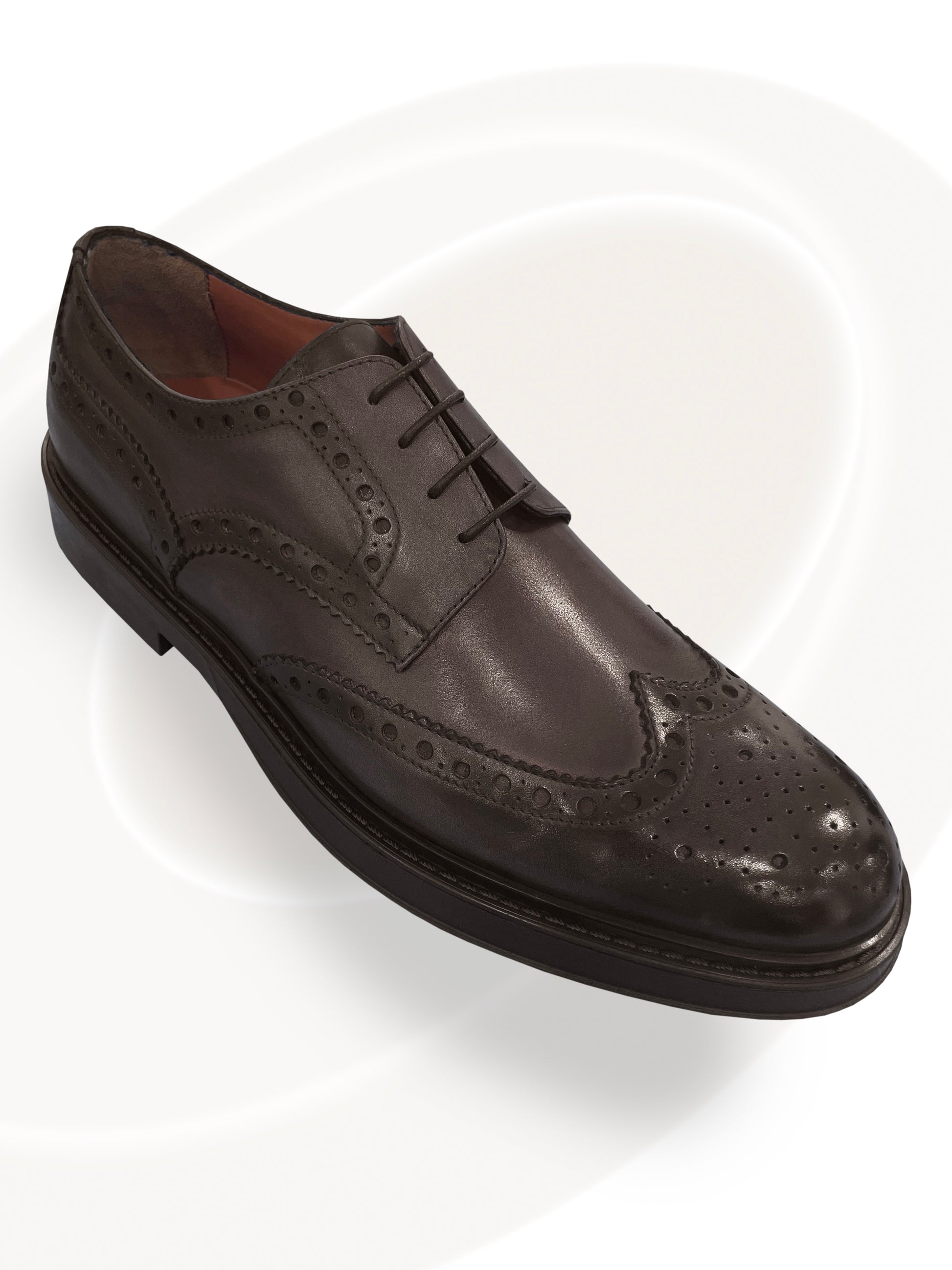 Brown leather wingtip shoe on a white background