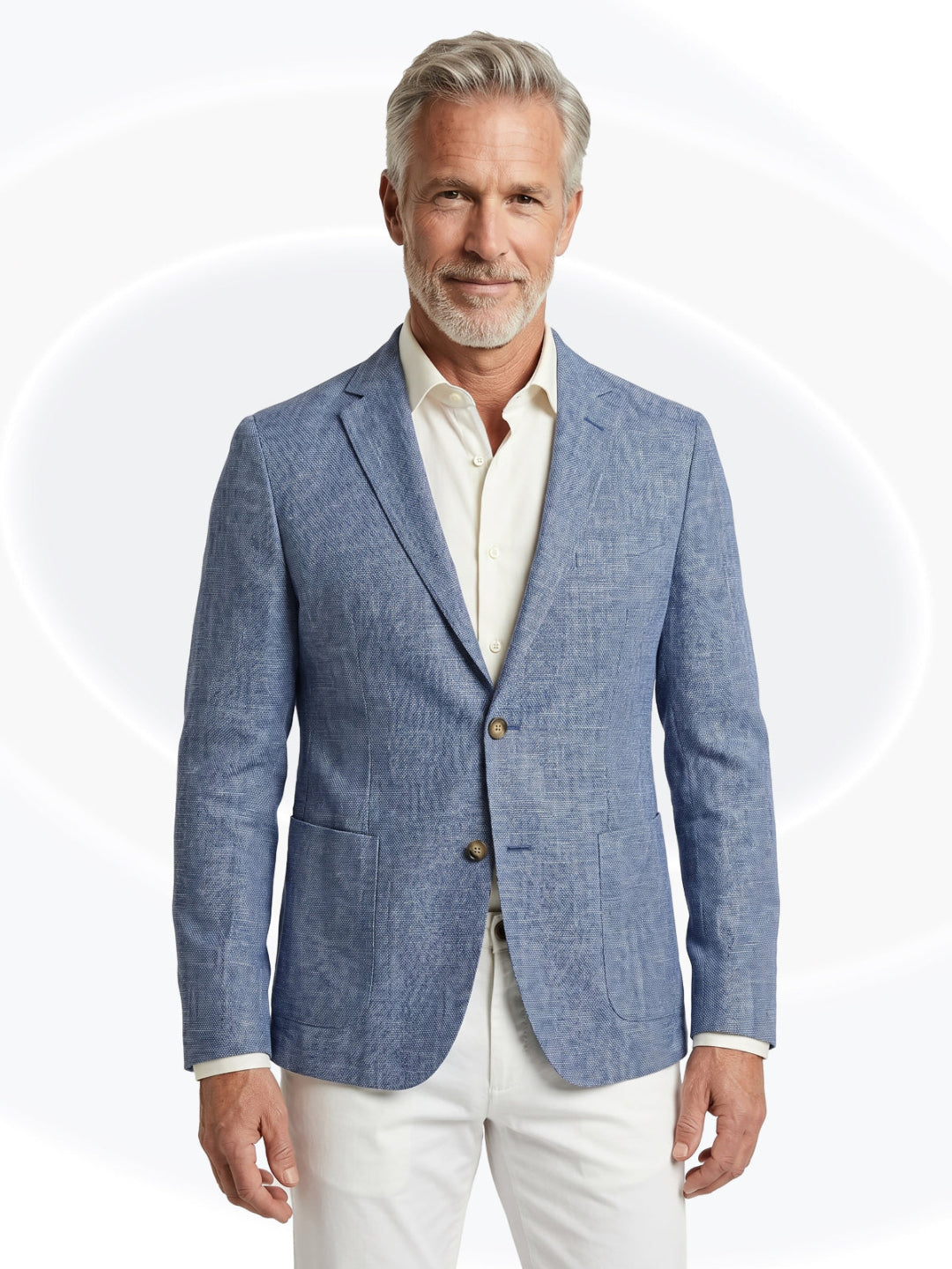 Man wearing a blue blazer over a white shirt and white pantson a white background