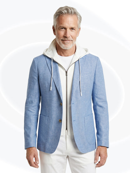 Man wearing a light blue blazer over a white hoodie on a white background
