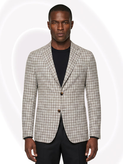 Man wearing a checkered blazer over a black shirt and black pants on a white background