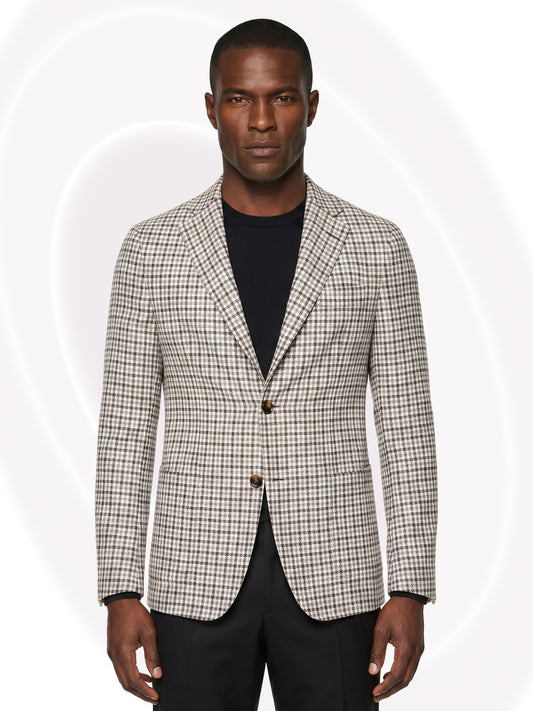 Man wearing a checkered blazer over a black shirt and black pants on a white background