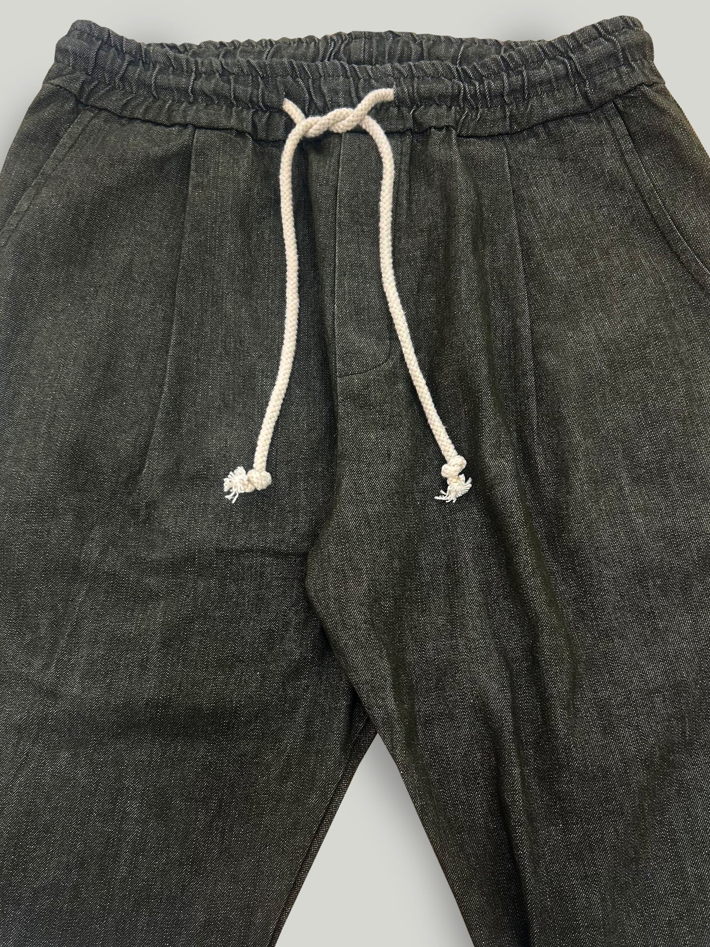 Military green pants with a drawstring on a light gray background