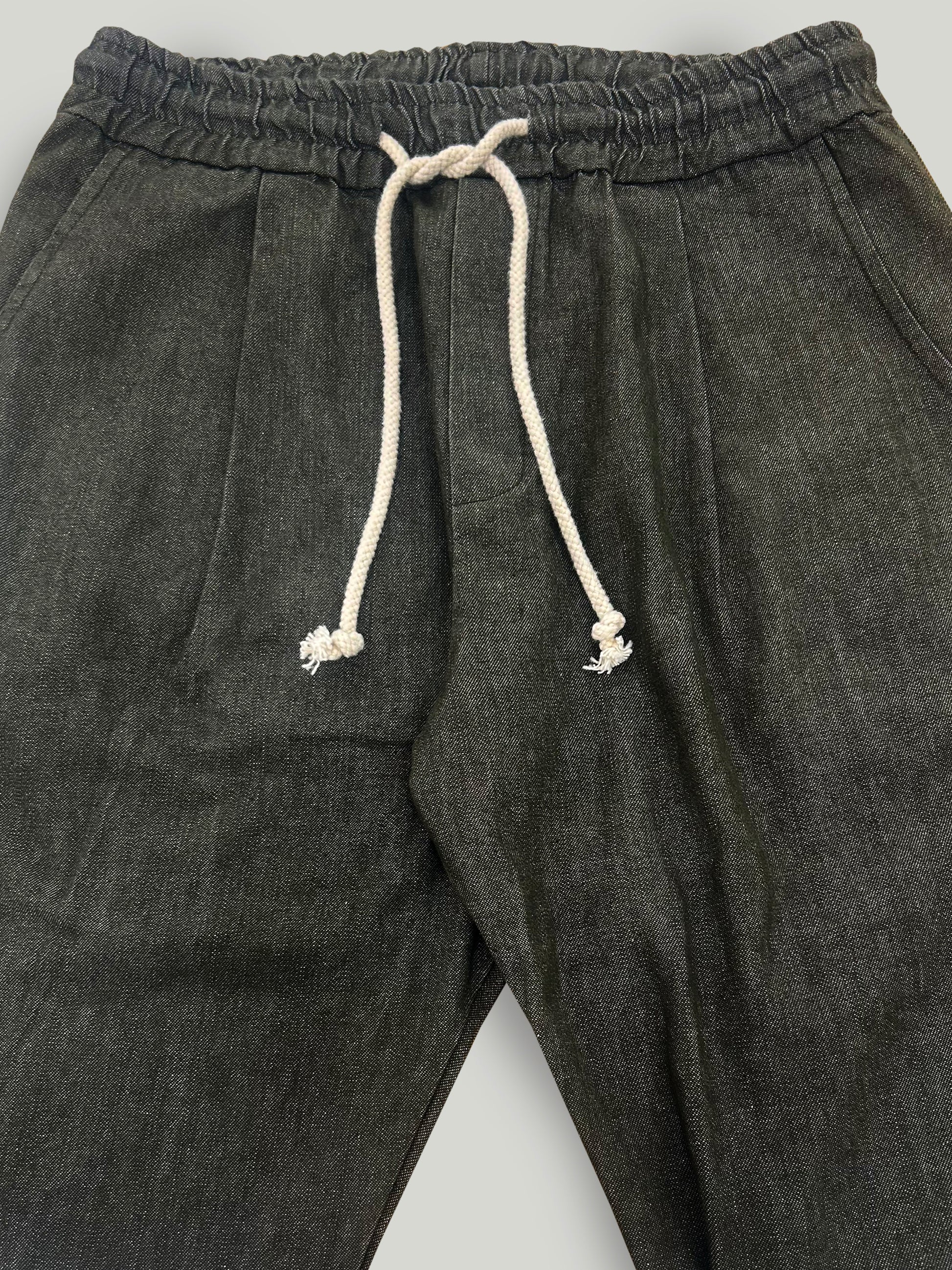 Military green pants with a drawstring on a light gray background