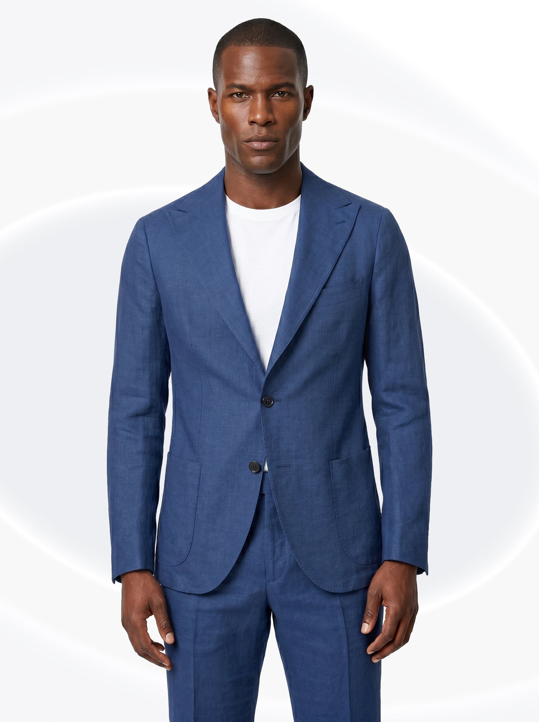 Man wearing a dark navy suit with a white t-shirt on a white background