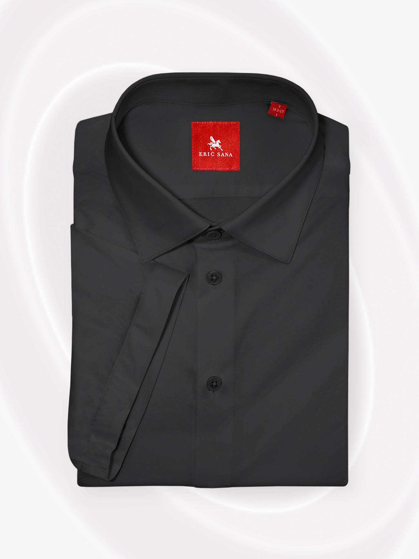 Black short-sleeve dress shirt neatly folded with a red Eric Sana logo label, displayed on a white background — Essential Shirt.