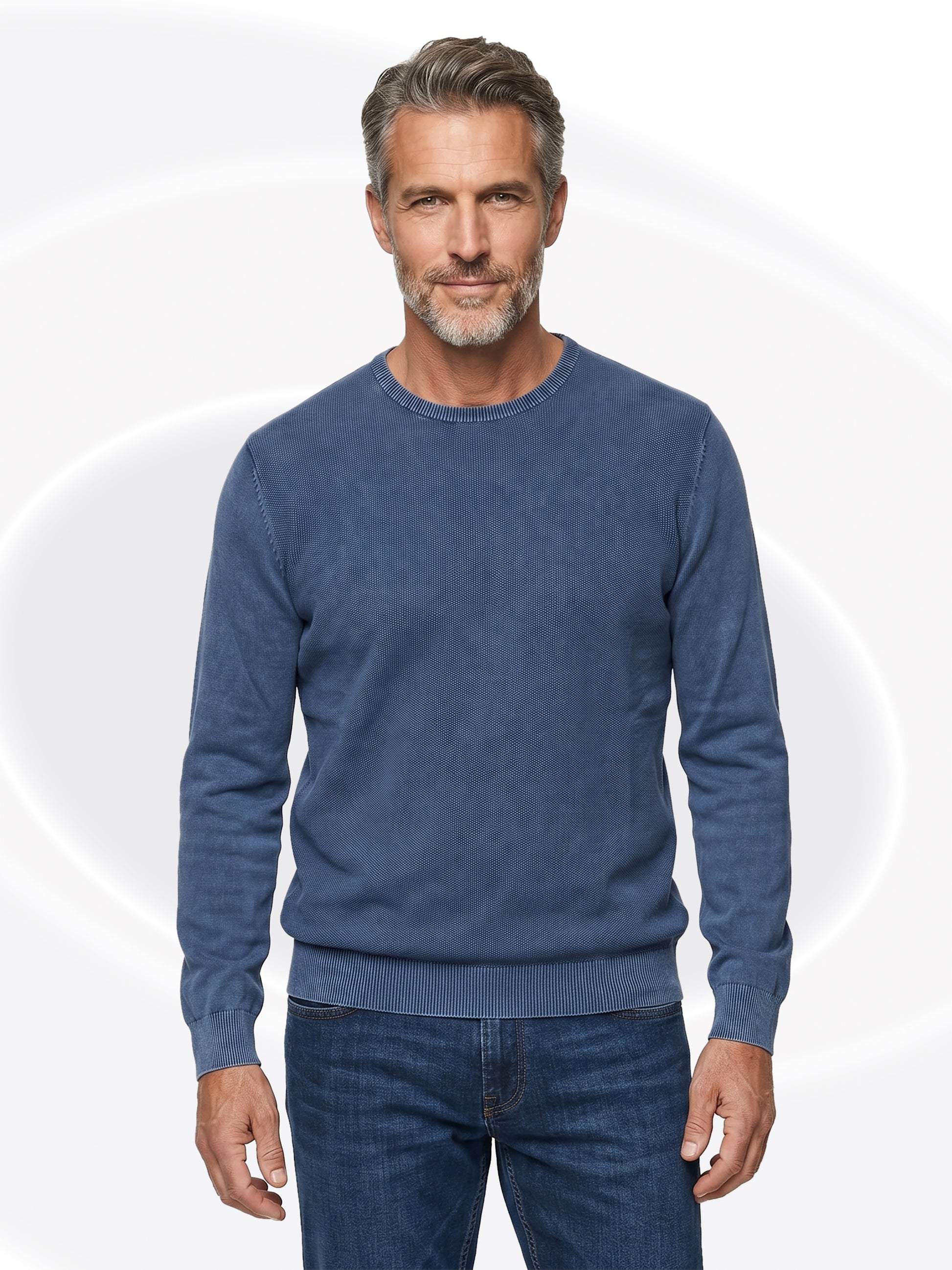 Man wearing a blue gray henley and jeans on a white background