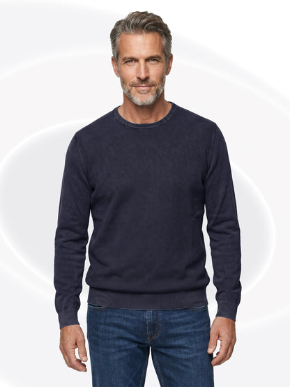 Man wearing a charcoal henley and jeans on a white background